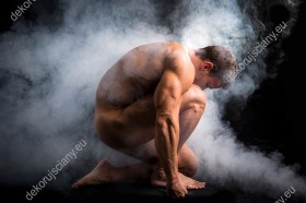 Wzornik, muskularny, mężczyzna skulony we mgle.