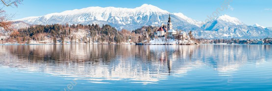 Wzornik fototapety z widokiem z panoramą na ośnieżone góry i wyspę na jeziorze, w zimowej scenerii. Fototapeta do pokoju dziennego, sypialni, salonu, biura, gabinetu, przedpokoju i jadalni.