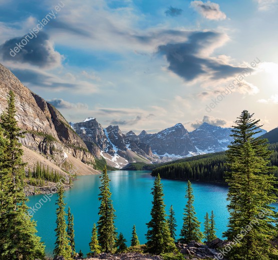 Wzornik fototapety z widokiem błękitnego jeziora, wysokich, ośnieżonych gór i zielonych lasów Patku Narodowego Banff w Kanadzie. Fototapeta do pokoju dziennego, sypialni, salonu, biura, gabinetu, przedpokoju i jadalni.
