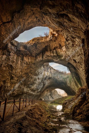 Wzornik fototapety przedstawia widok na niebo z jaskini Devetaki w Bułgarii. Rodzaj takiej fototapety świetnie sprawdzi się w pokoju dziennym, salonie, sypialni, przedpokoju, jadalni, biurze.