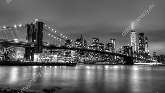 Wzornik, czarno-biała fototapeta przestawiająca oświetlony most Brooklyński nocą w Nowy Jork. Rodzaj takiej fototapety świetnie sprawdzi się w pokoju dziennym, salonie, sypialni, przedpokoju, jadalni, biurze oraz pokoju młodzieżowym.