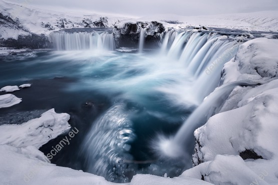 Wzornik obrazu w zimowym klimacie przedstawia wspaniały, ośnieżony wodospad bogów, Godafoss na Islandii. Obraz do pokoju dziennego, sypialni, salonu, biura, gabinetu, przedpokoju i jadalni.