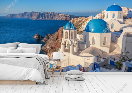 Wizualizacja fototapety z widokiem na tradycyjne, domy greckie - białe z niebieskimi dachami, na wyspie Santorini. Fototapeta do pokoju dziennego, młodzieżowego, sypialni, salonu, biura, gabinetu, przedpokoju i jadalni.