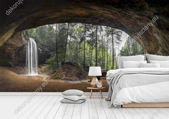 Wizualizacja fototapety z przedstawiająca las i wodospad widziane z wnętrza jaskini. Fototapeta do pokoju dziennego, sypialni, salonu, biura, gabinetu, przedpokoju i jadalni.