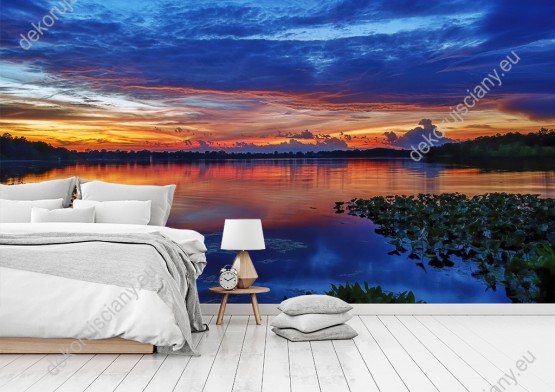 Wizualizacja fototapety przedstawia malowniczy zachód słońca nad tajemniczym jeziorem. Fototapeta do pokoju dziennego, sypialni, salonu, biura, gabinetu, przedpokoju i jadalni.