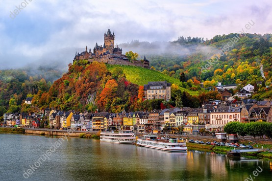 Wzornik fototapety z jesienna aurą, z widokiem na górskie miasto i zamek Cochem położone nad rzeką Mozelą w Niemczech. Fototapeta do salonu, sypialni, pokoju dziennego, gabinetu, biura, przedpokoju, jadalni.