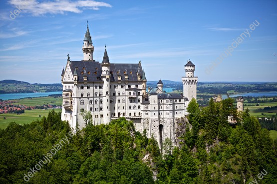 Wzornik fototapety z widokiem na biały zamek Neuschwanstein w Niemczech, na tle błękitnego nieba. Fototapeta do pokoju dziennego, sypialni, salonu, biura, gabinetu, przedpokoju i jadalni.