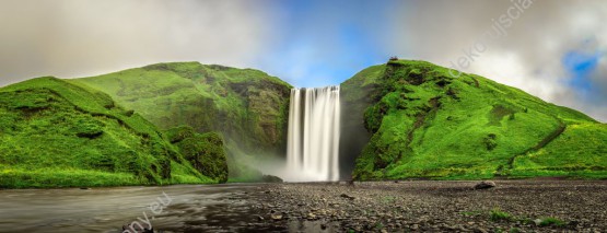 Wzornik obrazu z widokiem na wodospad wypływający z zielonych gór na Islandii. Obraz do pokoju dziennego, sypialni, salonu, gabinetu, biura, przedpokoju i jadalni.