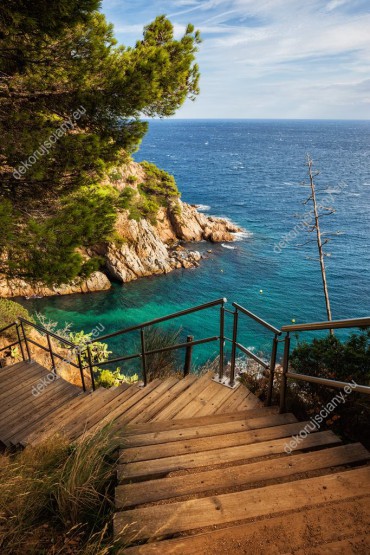 Wzornik obrazu z widokiem na drewniane schody prowadzące nad lazurowe morze w słonecznej Hiszpanii. Obraz do pokoju dziennego, salonu, sypialni, gabinetu, biura, przedpokoju i jadalni.