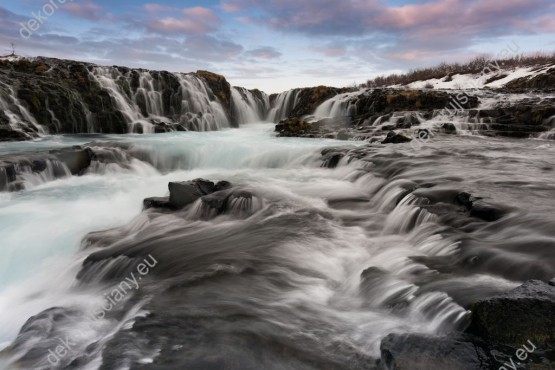 Wzornik obrazu z widokiem na szalejące wodospady Islandii spływające po kamieniach. Obraz do pokoju dziennego, salonu, sypialni, gabinetu, biura, przedpokoju i jadalni.