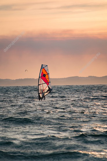 Wzornik obrazu przedstawia windsurfing na wzburzonych falach o zachodzie słońca. Obraz na ścianę do pokoju dziennego, salonu, sypialni, biura, gabinetu, przedpokoju.