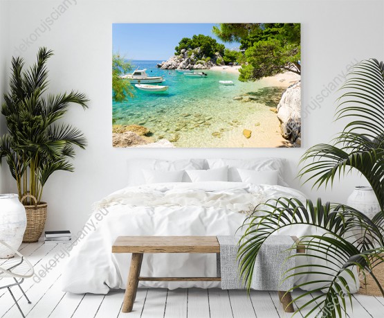 Wizualizacja obrazu z widokiem na rajską plażę i łódeczki na brzegu lazurowej wody. Klimatu dopełniają również skały i roślinność Chorwacji. Obraz do pokoju dziennego, sypialni, salonu, biura, gabinetu, przedpokoju i jadalni.