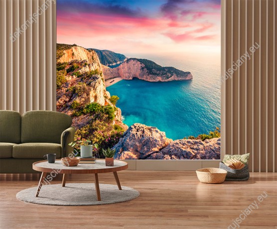 Wizualizacja fototapety z widokiem na piękny krajobraz skalnego wybrzeża i lazurowej wody przy plaży Shipwreck, w Grecji w kolorach zachodzącego słońca. Fototapeta do pokoju dziennego, sypialni, salonu, biura, gabinetu, przedpokoju i jadalni.