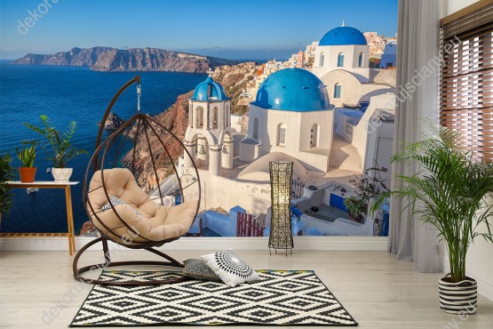 Wizualizacja fototapety z widokiem na tradycyjne, domy greckie - białe z niebieskimi dachami, na wyspie Santorini. Fototapeta do pokoju dziennego, młodzieżowego, sypialni, salonu, biura, gabinetu, przedpokoju i jadalni.
