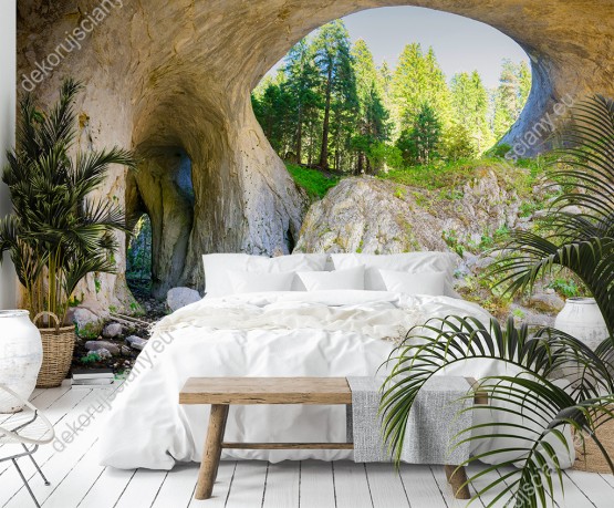 Wizualizacja fototapety przedstawia tunele w skalnej grocie z widokiem na zielony las. Fototapeta do pokoju dziennego, salonu, biura, gabinetu, sypialni, przedpokoju i jadalni.