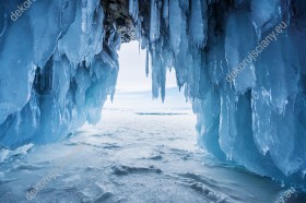 Wzornik fototapety z widokiem na zimowy krajobraz lodowej jaskini opromienionej światłem słonecznym. Fototapeta do pokoju dziennego, sypialni, salonu, biura, gabinetu, przedpokoju i jadalni.