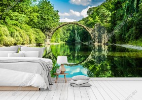 Wizualizacja fototapety przedstawia kamienny most w nad wodą, w wiosennych barwach soczystej zieleni. Miejsce  Kromlau w Niemczech. Fototapeta przeznaczona do sypialni, salonu, biura, gabinetu, pokoju młodzieżowego.