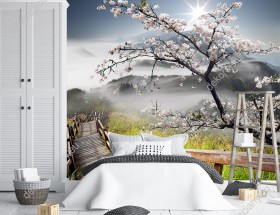 Wizualizacja fototapety w japońskim wiosennym, klimacie z drewnianym mostem, drzewem kwitnącej wiśni i górami. Fototapeta przeznaczona do pokoju dziennego, salonu, sypialni, biura, gabinetu.