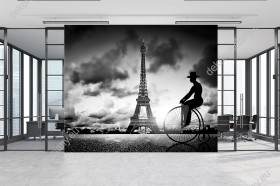 Wizualizacja, czarnobiała fototapeta z motywem mężczyzny jadącego na rowerze retro w okolicach Wieży Eiffla, w Paryżu. Fototapeta w nowoczesnym stylu do pokoju młodzieżowego, salonu, sypialni a nawet biura.