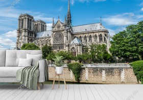 Wizualizacja fototapety z widokiem na gotycką Katedrę Notre Dame w Paryżu, wśród bujnej zieleni. Katedra jest jedną z najbardziej znanych na całym świecie. Fototapeta do salonu, sypialni, pokoju dziennego, gabinetu, biura, przedpokoju.