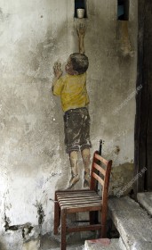 Wzornik fototapety z kategorii murali, przedstawia chłopca na krześle wspinającego się po małą zdobycz. Fototapeta do pokoju dziennego, dziecięcego, młodzieżowego, sypialni, salonu, biura, gabinetu, przedpokoju i jadalni.