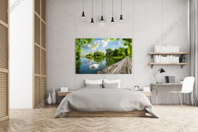Wizualizacja obrazu z pięknym widokiem na drewniany pomost nad wodą, pływającego łabędzia i zielone drzewa. Obraz przeznaczony do salonu, sypialni, pokoju młodzieżowego, gabinetu czy biura.